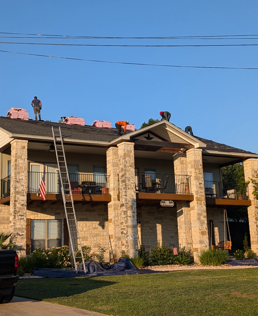 a team of workers installing asphalt roofing